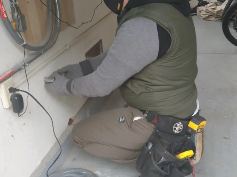 Electrician performing outlet wiring in a Amityville garage